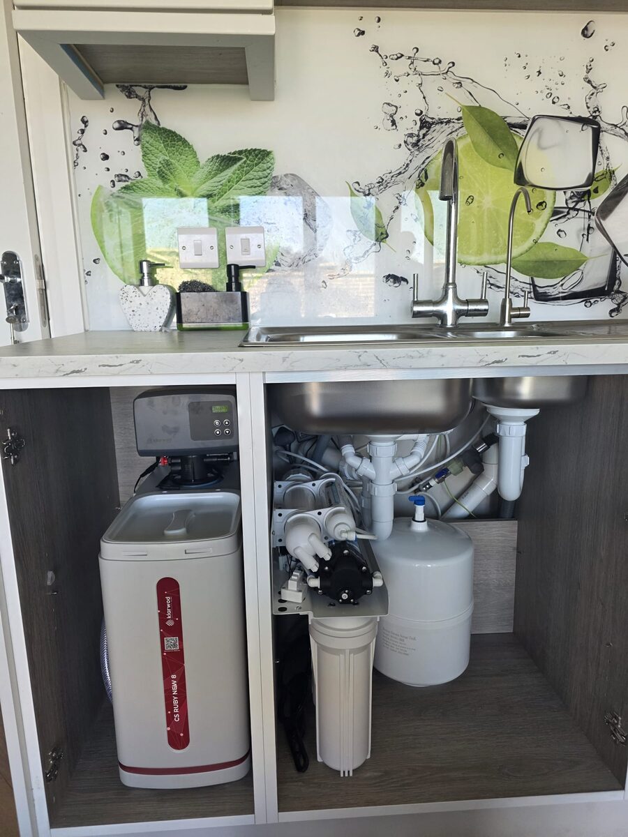 Softener and reverse osmosis system with pump and storage tank across two cabinets