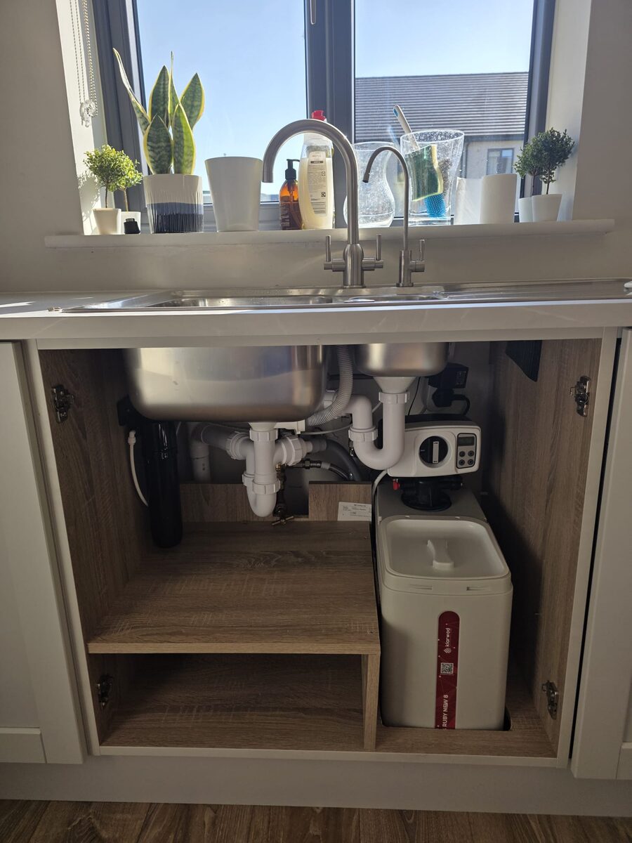 Softener installed beside a double sink with two taps and a carbon filter