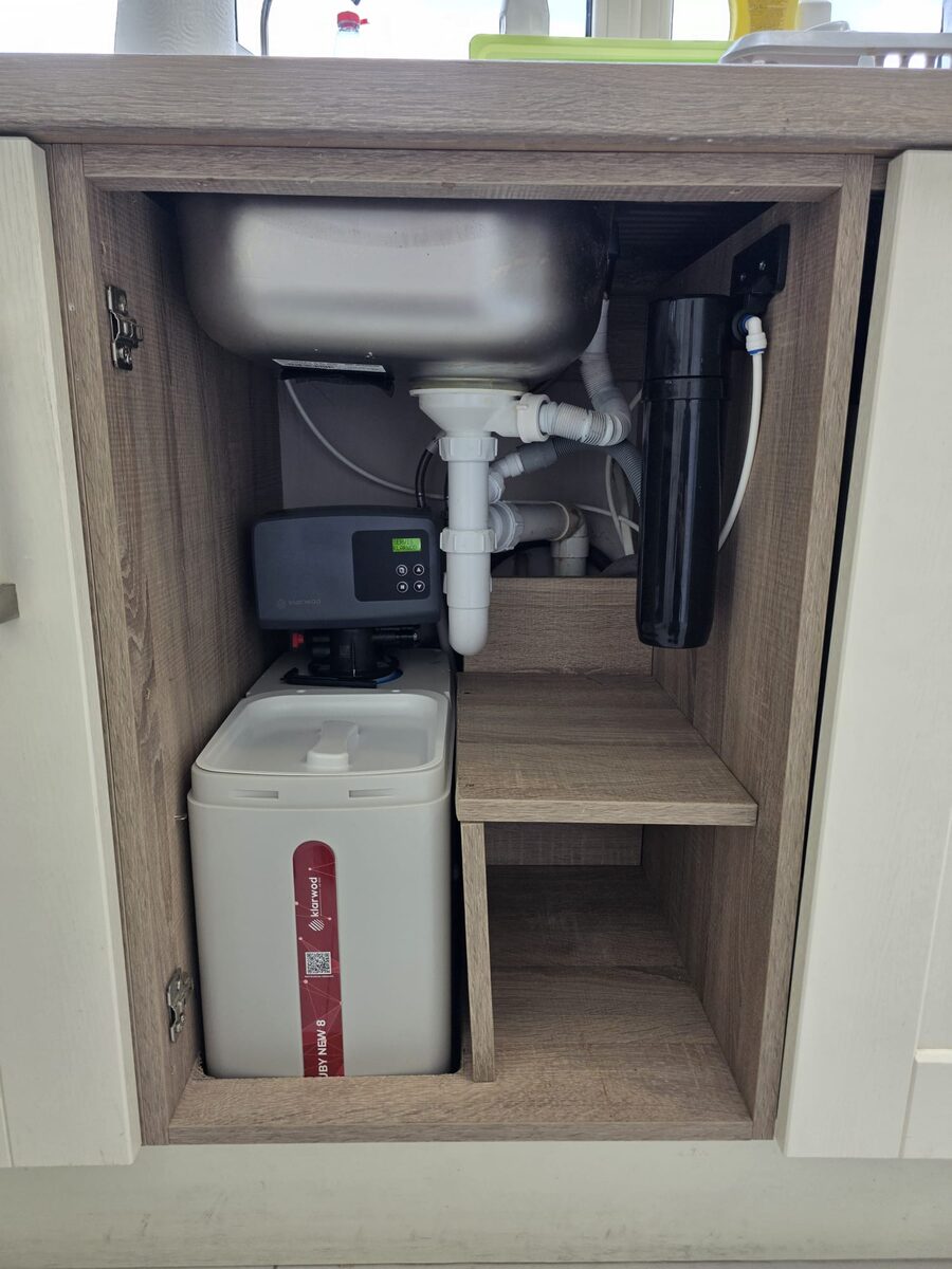 Softener with a black in-line carbon drinking water filter mounted in the cabinet